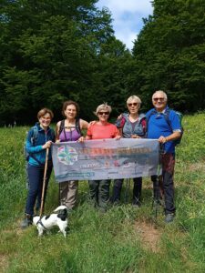 escursionisti nel prato in posa per la foto con striscione